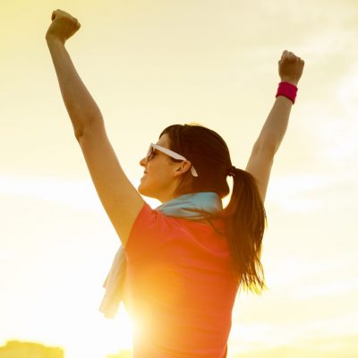 Girl with arms raised after a run