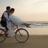 Newlyweds right a bike on the beach